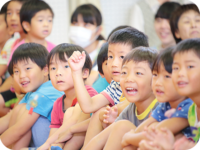 座って先生の話を聞く子どもたち